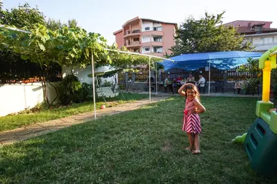 a little girl standing in the grass at Guest House Gardeli in Tsarevo