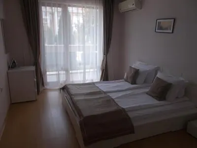 a bedroom with a large bed with a large window at Private Apartment 49 in Prestige Fort Beach Hotel in Sveti Vlas