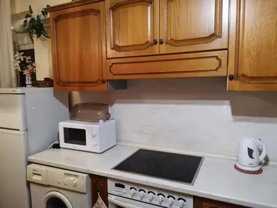 a kitchen with a stove top oven next to a microwave at Къща за гости Слънчевият ъгъл - The sunny corner in Sozopol