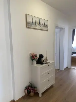 a bedroom with a white dresser and a picture on the wall at Къща за гости Слънчевият ъгъл - The sunny corner in Sozopol