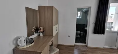 a bathroom with a wooden dresser and a mirror at Къща за гости Слънчевият ъгъл - The sunny corner in Sozopol