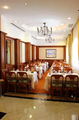 a dining room with tables and chairs and a chandelier at Helena Park - Ultra All Inclusive in Sunny Beach