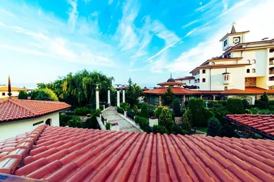 a building with a red roof and a tower at Helena Park - Ultra All Inclusive in Sunny Beach