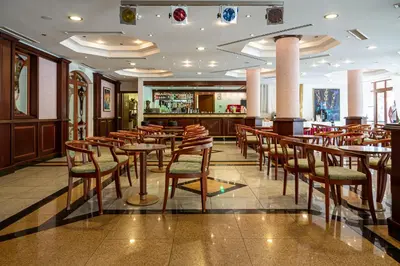 a restaurant with tables and chairs and a bar at Helena Park - Ultra All Inclusive in Sunny Beach