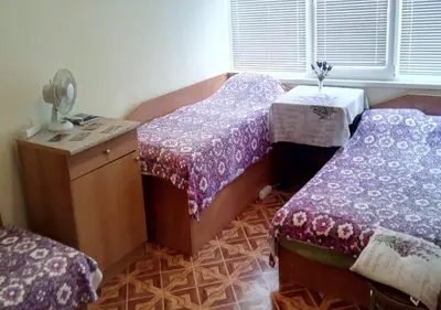 a room with two twin beds and a table at Апартамент Флора - гр.Приморско ММЦ in Primorsko