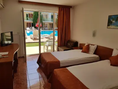 a hotel room with two beds and a balcony at Sun City Hotel in Sunny Beach