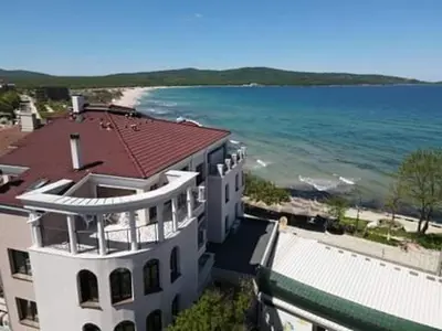 a large white building next to the ocean at Ashram Hotel in Primorsko