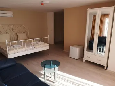a living room with a bed and a mirror at Ashram Hotel in Primorsko