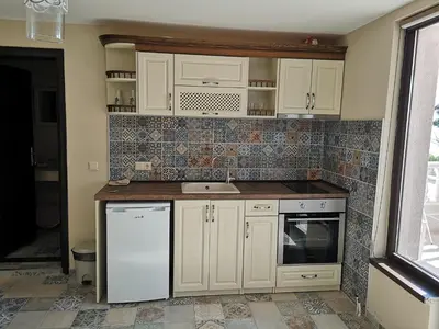 a kitchen with white cabinets and a sink at Ashram Hotel in Primorsko