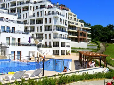 a large white apartment building with a swimming pool at Апартаменти Бяла Клиф на плажа - Apartments Byala Cliff First Line in Byala