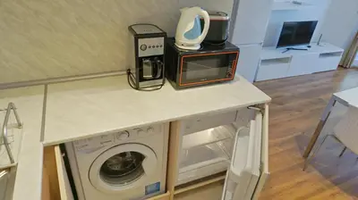 a kitchen counter with a washing machine and a microwave at Апартаменти Бяла Клиф на плажа - Apartments Byala Cliff First Line in Byala