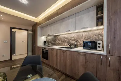 a kitchen with wooden cabinets and a microwave at Apartments Cats in Varna City