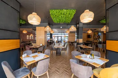 a restaurant with tables and chairs and lights at Avenue Hotel Deluxe in Burgas City