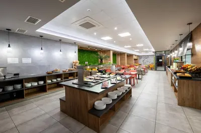a restaurant with a buffet line of food at Avenue Hotel Deluxe in Burgas City