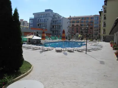 a swimming pool with lounge chairs and umbrellas at SB Rentals Apartments in Royal Dreams Complex in Sunny Beach