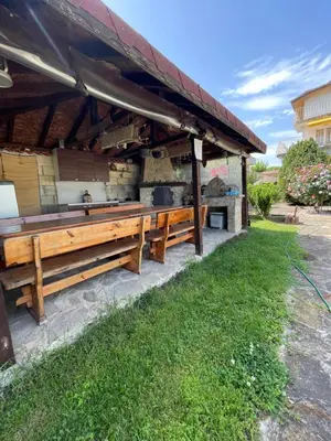 a patio with a wooden bench and a grill at The White House in Bliznatsi