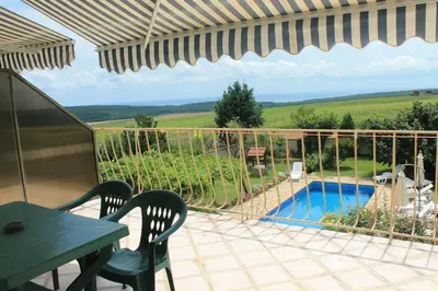 a patio with a table and chairs and a swimming pool at The White House in Bliznatsi