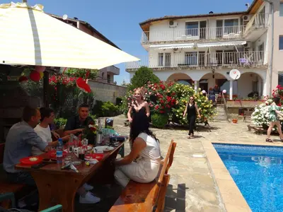 a group of people sitting at a table by a pool at The White House in Bliznatsi