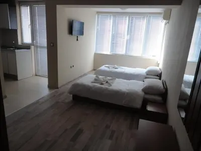 a bedroom with a bed in a room with windows at Casa Luba Sunny beach in Sunny Beach