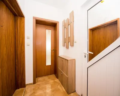 a hallway with a wooden door and a wooden cabinet at Aleksapart in Burgas City