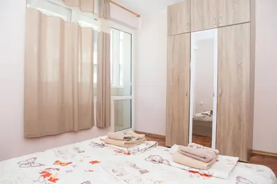 a bedroom with a bed and a mirror at Aleksapart in Burgas City