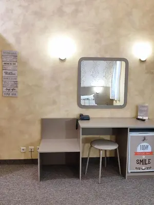 a mirror on a wall with a desk and a chair at Семеен Хотел 