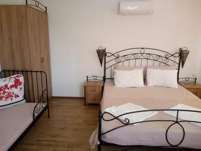 a bedroom with a bed and a chair in it at Family Hotel Bellehouse in Chernomorets