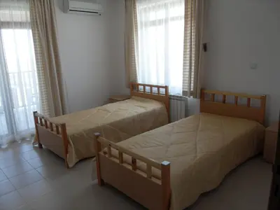 two beds in a room with windows at HillTop Villa in Burgas City