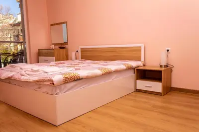 a bedroom with a bed and a table with a candle at New Star Residence in Burgas City