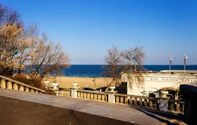 a building next to a beach with the ocean at New Star Residence in Burgas City