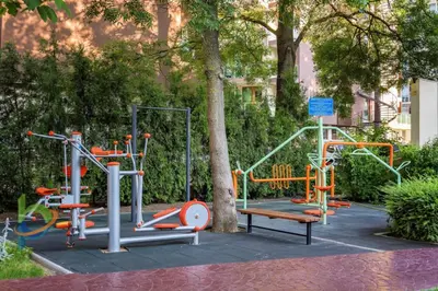 a playground with colorful equipment in a park at Excelsior Holiday Apartments Sunny Beach in Sunny Beach