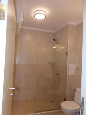 a bathroom with a glass shower with a toilet at Atia Resot in Chernomorets