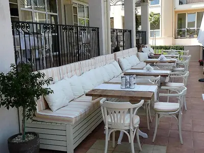 a row of tables and white couches on a patio at Atia Resot in Chernomorets