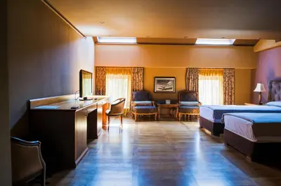 a hotel room with two beds and a desk at Ventura Boutique Hotel in Varna City