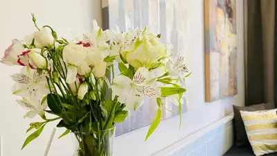 a vase filled with white flowers sitting on a table at APARTELLO Modern Apartments - CASA REAL in Sveti Vlas in Sveti Vlas