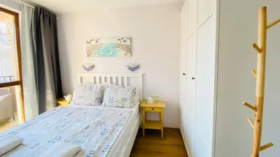 a small bedroom with a bed and a table at APARTELLO Modern Apartment - Balkan Breeze 7 in Sunny Beach