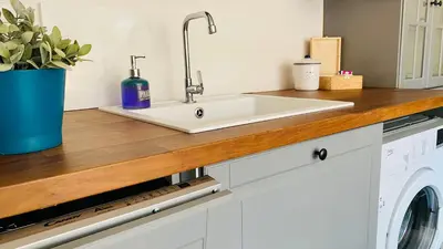 a kitchen counter with a sink and a washer and dryer at APARTELLO Modern Apartment - Balkan Breeze 7 in Sunny Beach