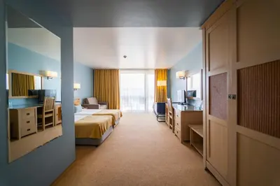 a hotel room with two beds and a desk at HVD Clubhotel Miramar - 24 Hours Ultra All Inclusive & Free Parking in Obzor