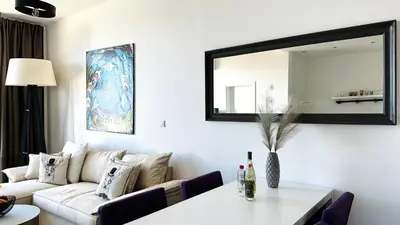 a living room with a white couch and a mirror at APARTELLO Modern Apartment - Garden of Eden in Sveti Vlas