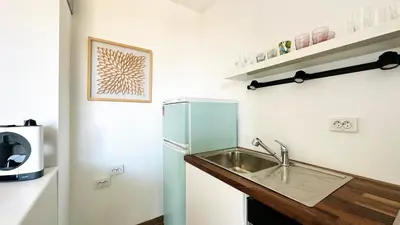 a small kitchen with a sink and a refrigerator at APARTELLO Modern Apartment - Garden of Eden in Sveti Vlas