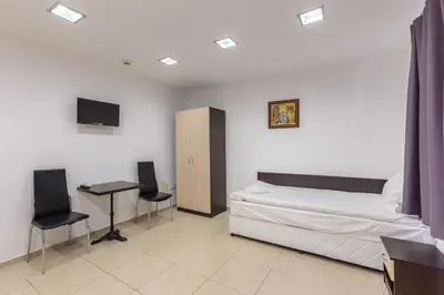 a bedroom with a bed and two chairs and a desk at СТАИ ЗА ГОСТИ ХАН КРУМ in Burgas City
