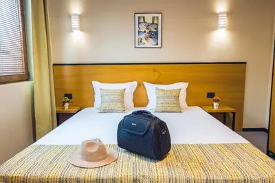 a hotel room with a bed with a hat on it at Hotel Albatros New Town in Sozopol