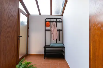 a hallway with a black chair in a house at Hotel Albatros Old Town in Sozopol