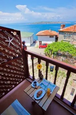 a table with a plate of food on a balcony at Hotel Albatros Old Town in Sozopol