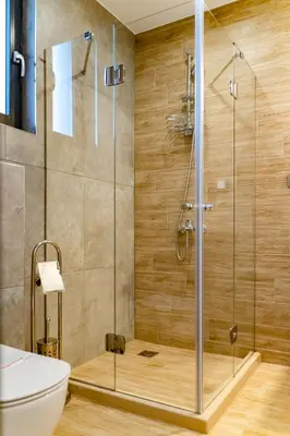 a shower with a glass door in a bathroom at Family Hotel LAXO in Obzor