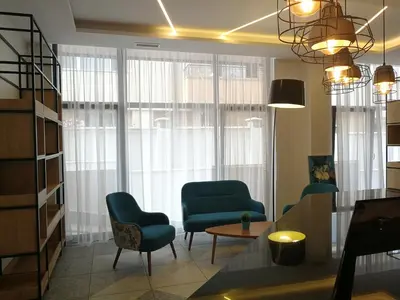 a living room with two blue chairs and a table at Family Hotel LAXO in Obzor