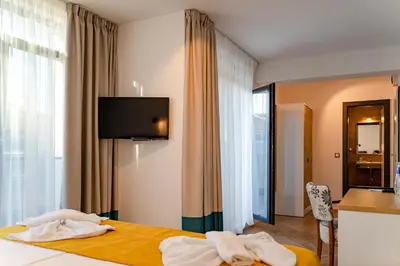 a hotel room with a bed with towels on it at Family Hotel LAXO in Obzor