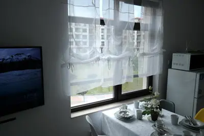 a room with a table and a window with white curtains at Aivazovsky Park Anchialos H14 in Pomorie
