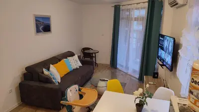 a living room with a couch and a tv at Aivazovsky Park Anchialos H14 in Pomorie