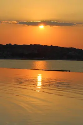 a sunset over a body of water at Apartments 